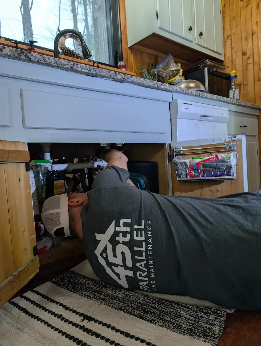 Plumbing repair under kitchen sink by 45th Parallel Home Maintenance in Traverse City